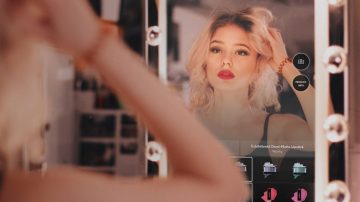 Photograph of a woman using the Covergirl magic mirror.