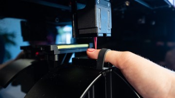 Photograph of someone getting a robot manicure.