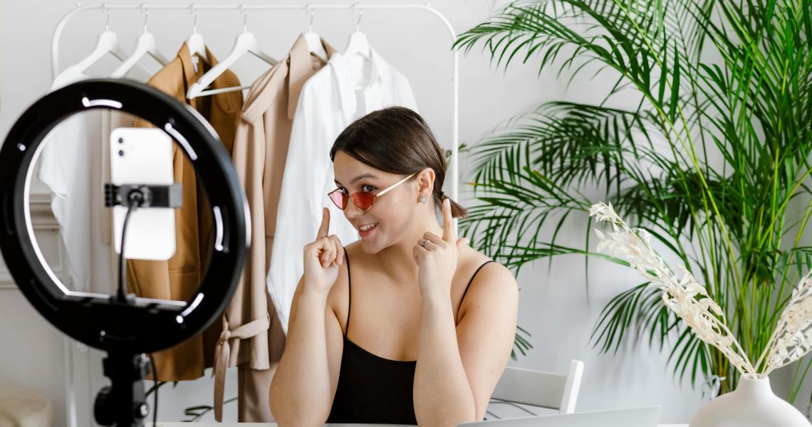 influencer girl recording herself with a ring light. Creating user generated content (UGC) showing her glasses for cyber monday and black friday sales.