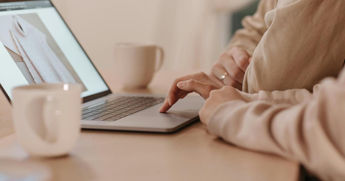 Two people browsing a fashion website on a laptop, illustrating how AI in customer service supports seamless online shopping experiences.